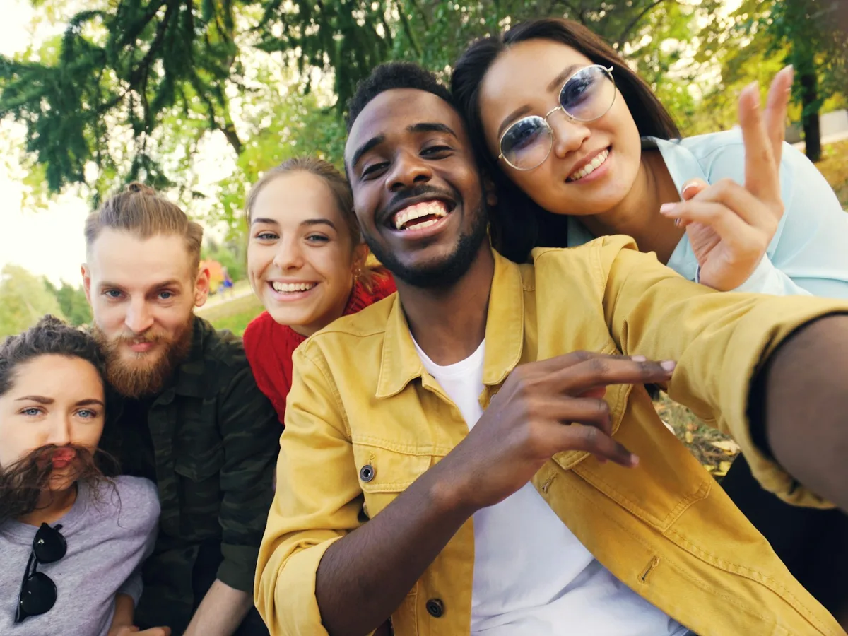 Un groupe d'amis divers souriant ensemble en pleine nature